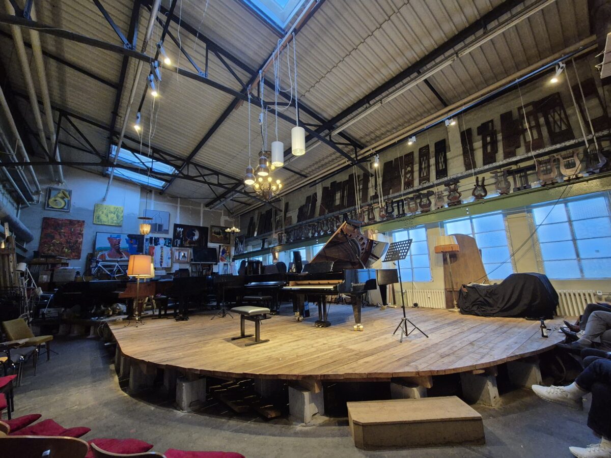 blick auf die bühne im pianosalon christophori, man sieht einen flügel im vordergrund und ein paar andere im hintergrund
